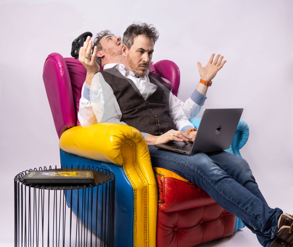 Nils aan het werk op een gekleurde fauteuil met een laptop op schoot en controller in de hand